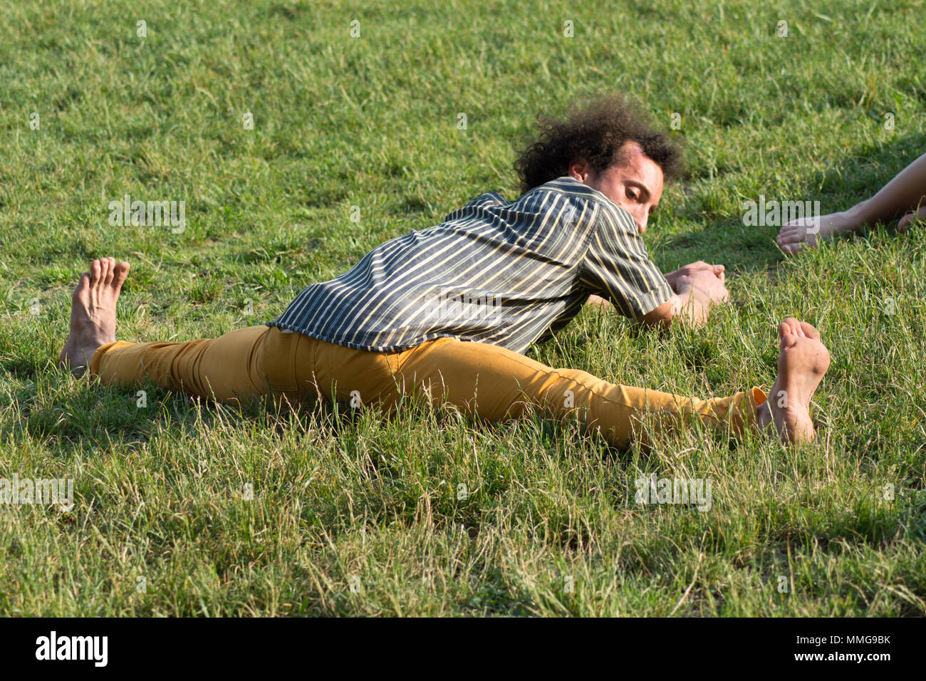 Rückansicht eines Kerls, Stretching oder Yoga machen Stockfoto