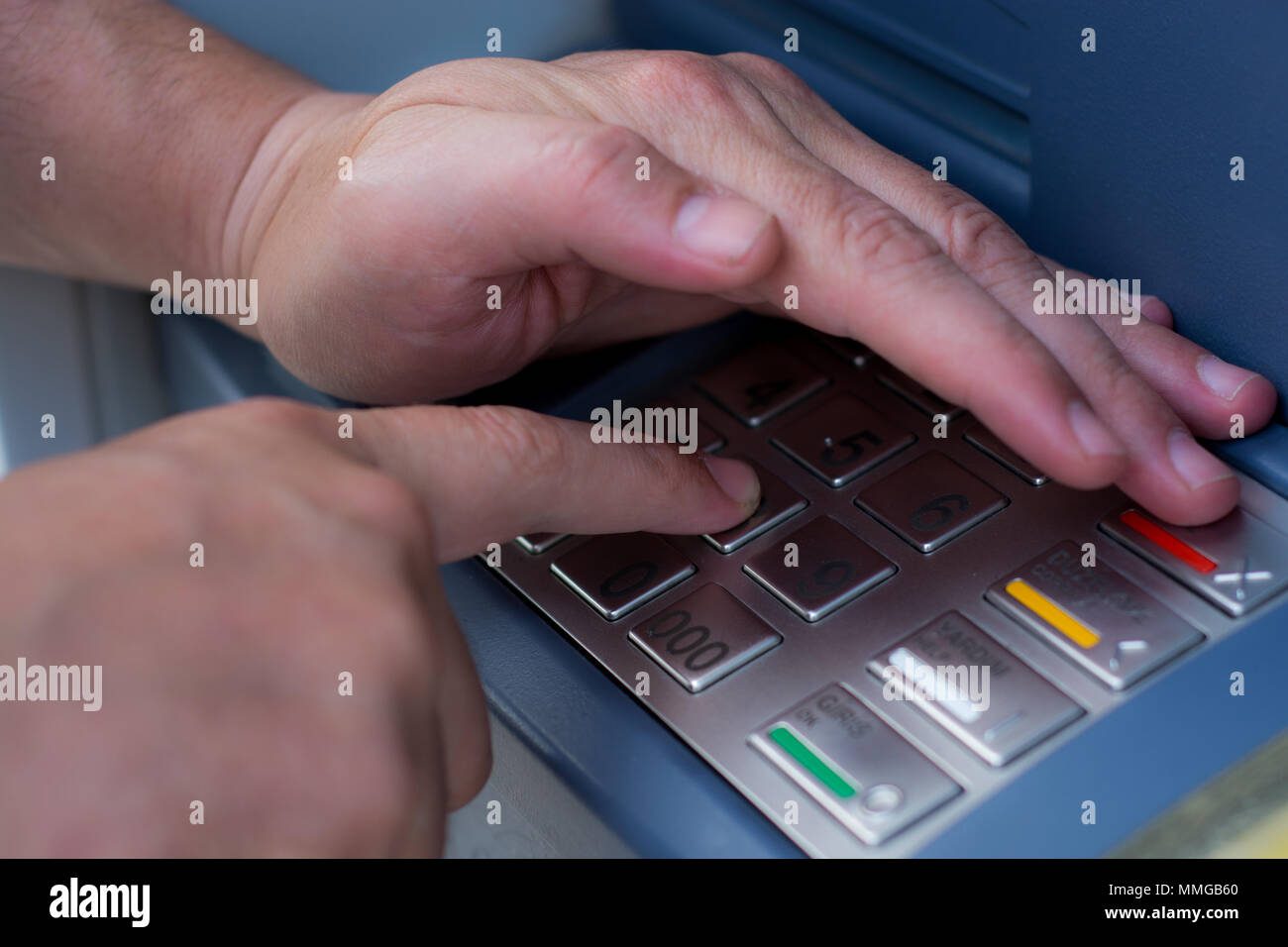 Hand wählt die PIN-Code an einem Geldautomaten Stockfoto
