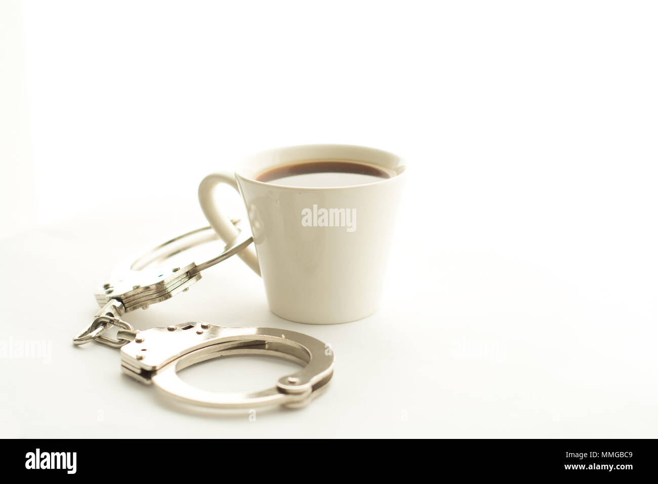 Handschellen mit Kaffee Stockfoto