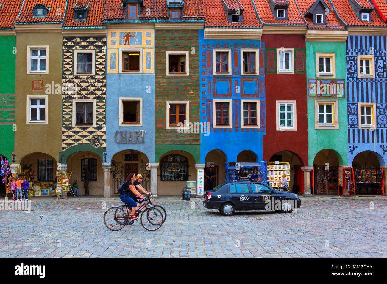 POZNAN, Polen - 10. JUNI 2013: Marktplatz in der Altstadt. Stadt Landschaft. Marktplatz in der Altstadt. Stadt Landschaft. Zwei Mädchen auf dem Fahrrad ri Stockfoto