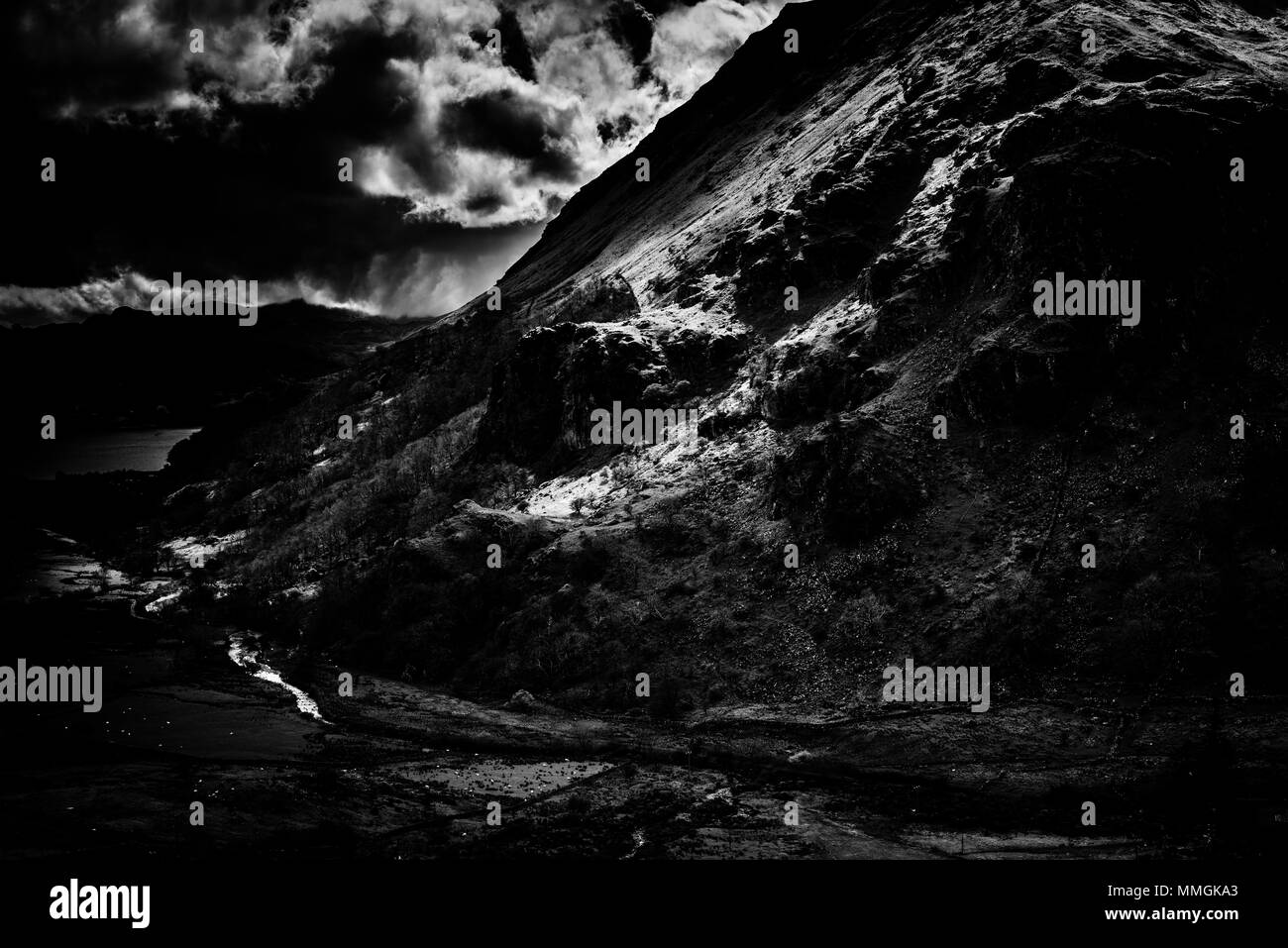 Dunkel und Moody schwarz-weiß Foto von dappled Licht auf der östlichen Seite des Mount Snowdon an einem Sommertag Stockfoto