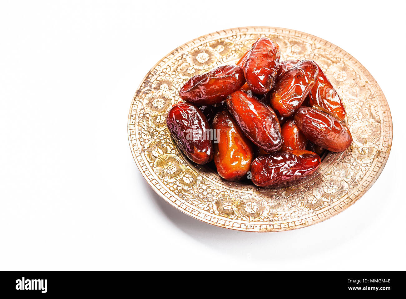 Getrocknete Datteln auf einem traditionellen Fach auf einem weißen Hintergrund. Ramadan Kareem Stockfoto