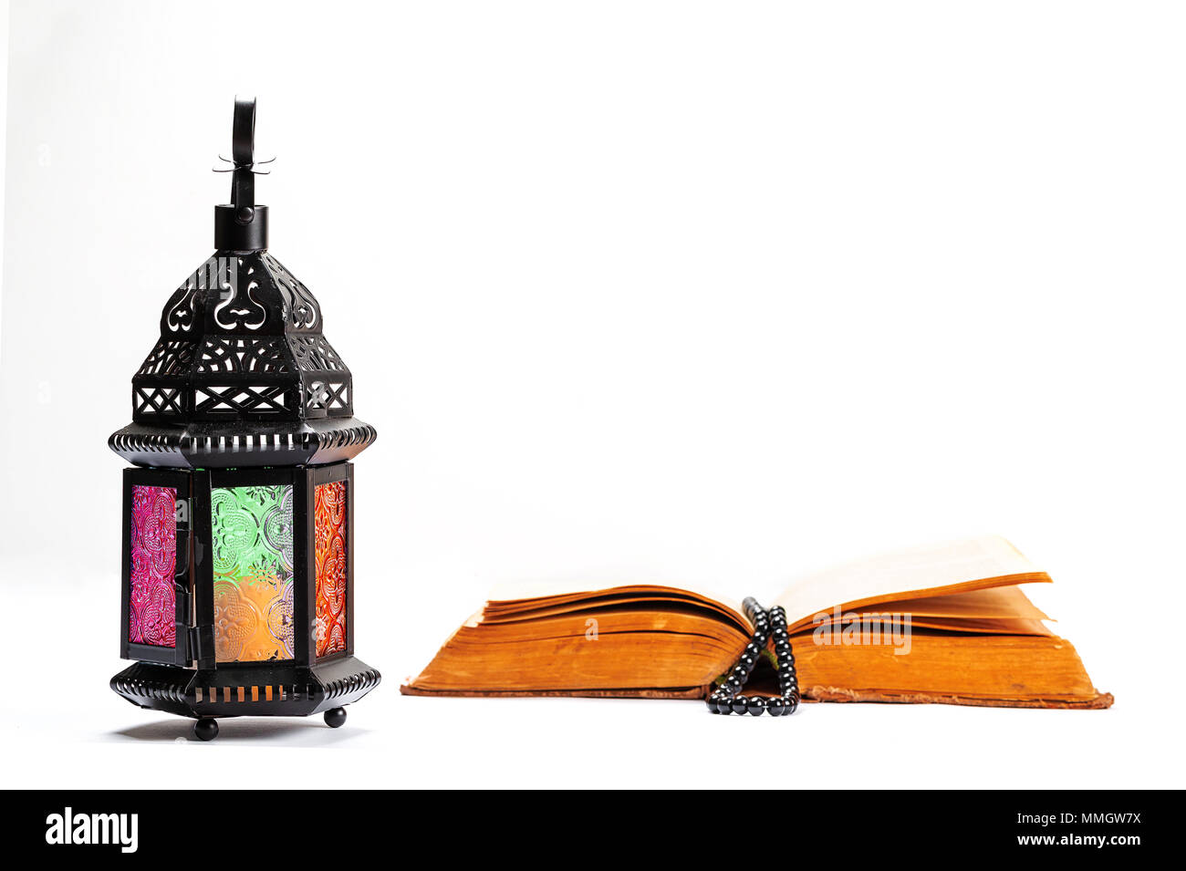 Islamische heilige Buch Koran mit Rosenkranz unter weiches Licht auf weißem Hintergrund mit einem leuchtenden Laternen Fanus. Ramadan Konzept. Drei Monate. Stockfoto
