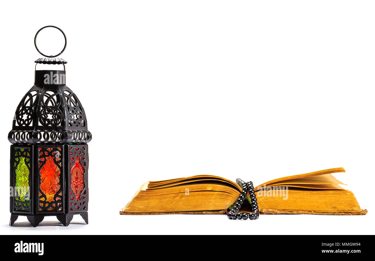 Islamische heilige Buch Koran mit Rosenkranz unter weiches Licht auf weißem Hintergrund mit einem leuchtenden Laternen Fanus. Ramadan Konzept. Drei Monate. Stockfoto