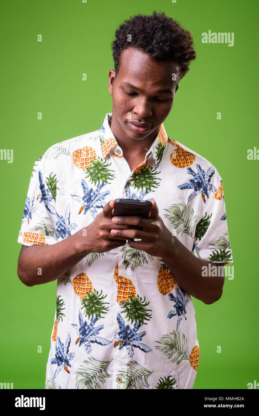 Junge afrikanische touristische Mann bereit für Ferienhäuser gegen grüne Hinterg Stockfoto