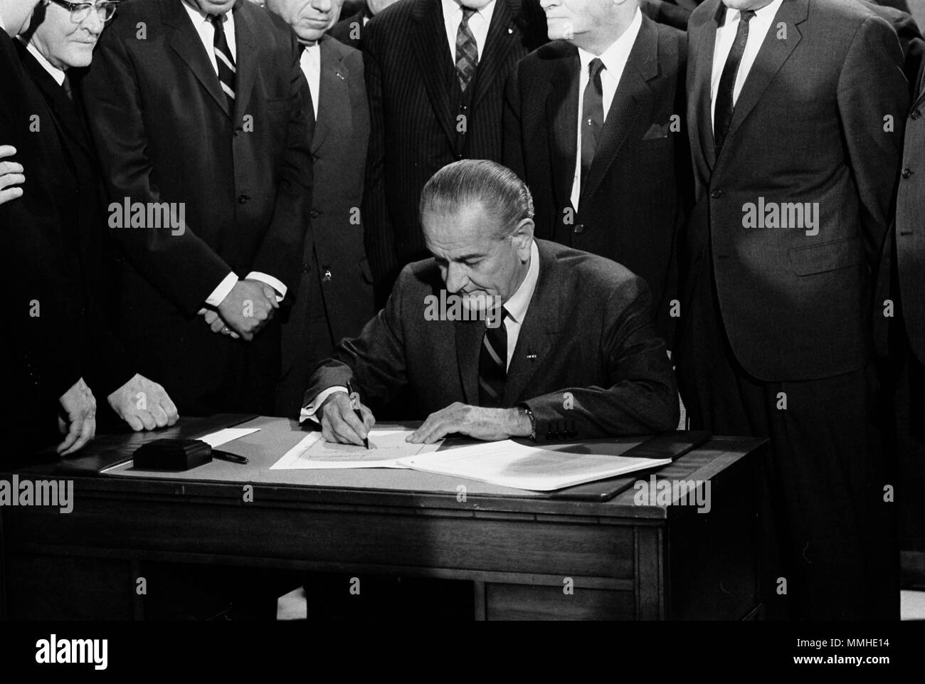 Präsident Johnson bei der Unterzeichnung des Civil Rights Act von 1968, während in einer Tabelle durch Mitglieder des Kongresses umgeben sitzt. 11. April 1968 Stockfoto