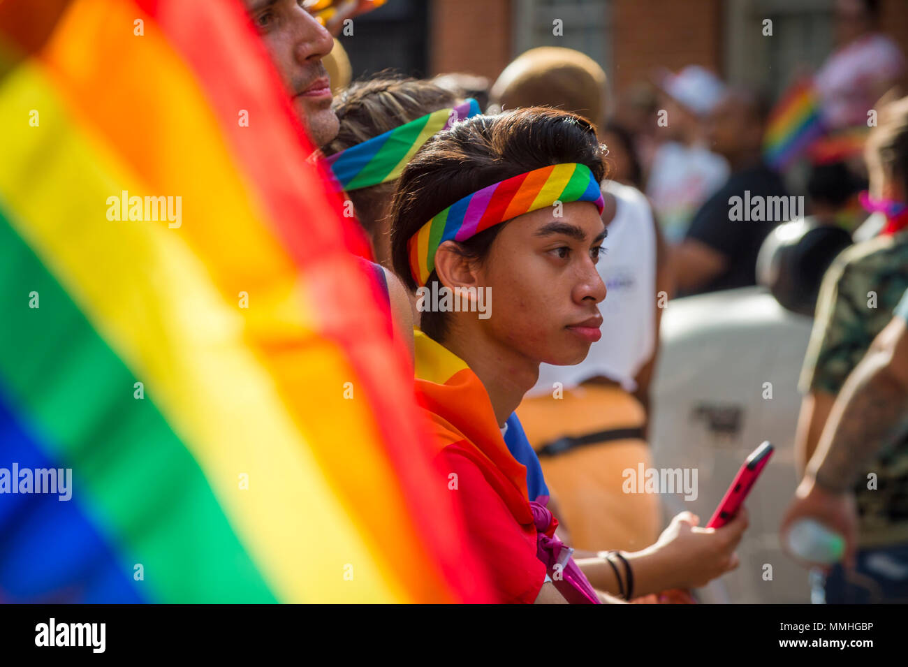 NEW YORK CITY - 25 Juni, 2017: Teilnehmer wave Regenbogenfahnen auf einen Schwimmer in der jährlichen Pride Parade durch Greenwich Village. Stockfoto