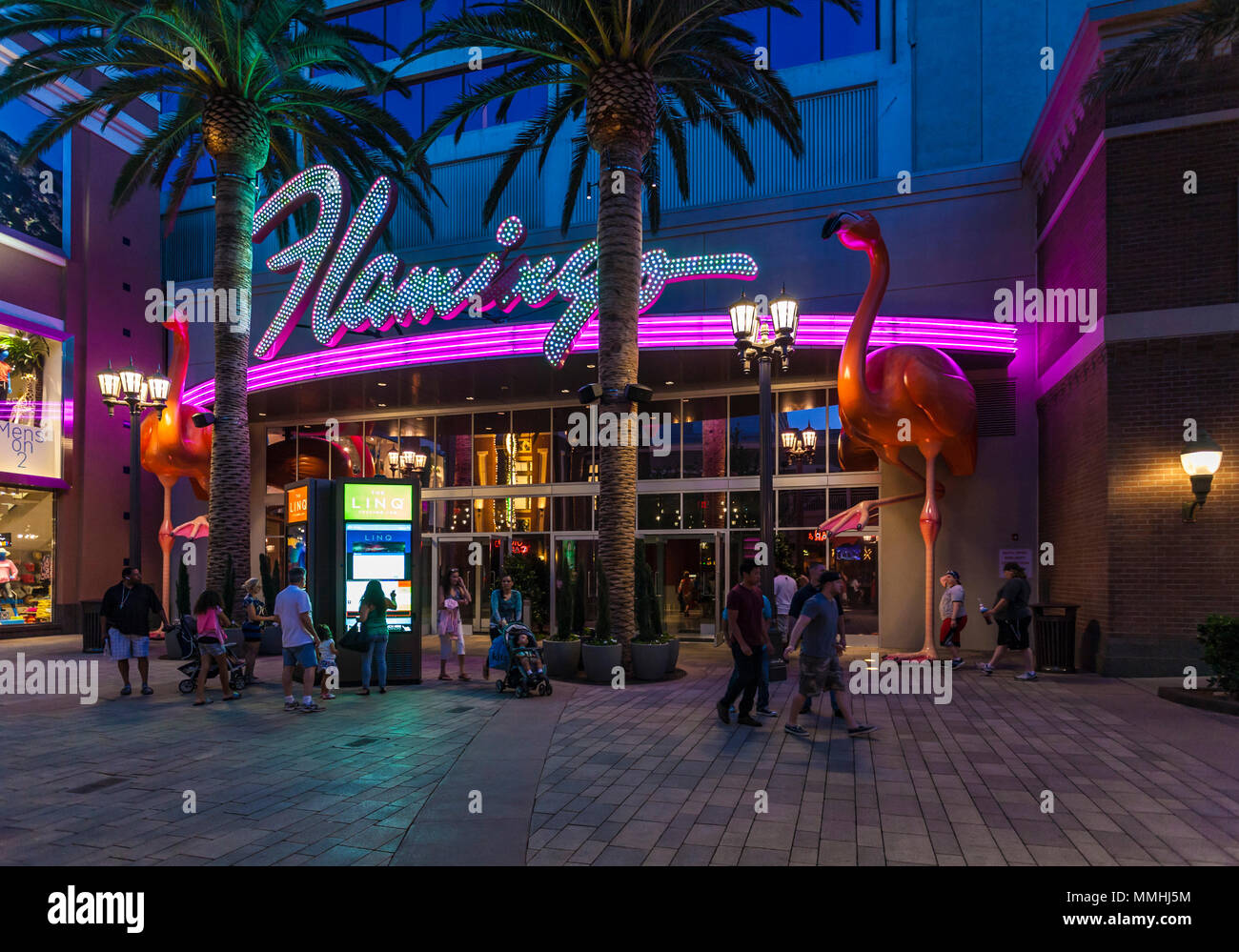 Touristen zu Fuß vorbei an den lila und rosa Neonlicht am Eingang des Flamingo Las Vegas Hotel & Casino auf dem Las Vegas Strip im Paradies, Nevada Stockfoto