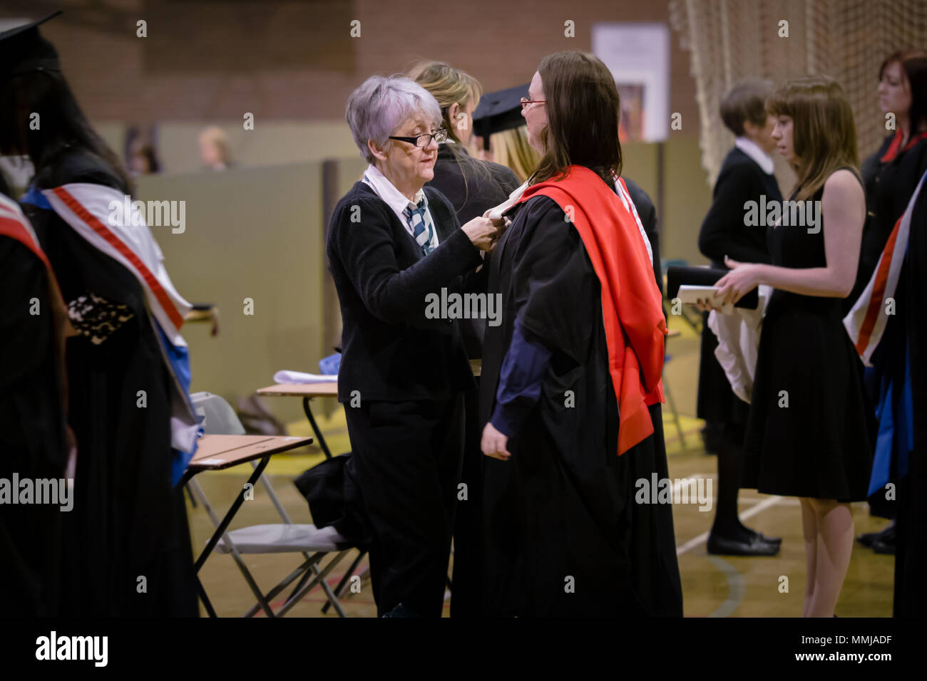 Absolventinnen, gekleidet in Gewänder, Kappen & Mützen/Mortarboards für Abschlussfeier - Universität Chester, England Stockfoto