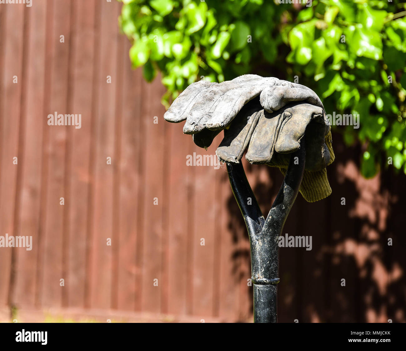 Gartenhandschuhe auf einem Griff Stockfoto