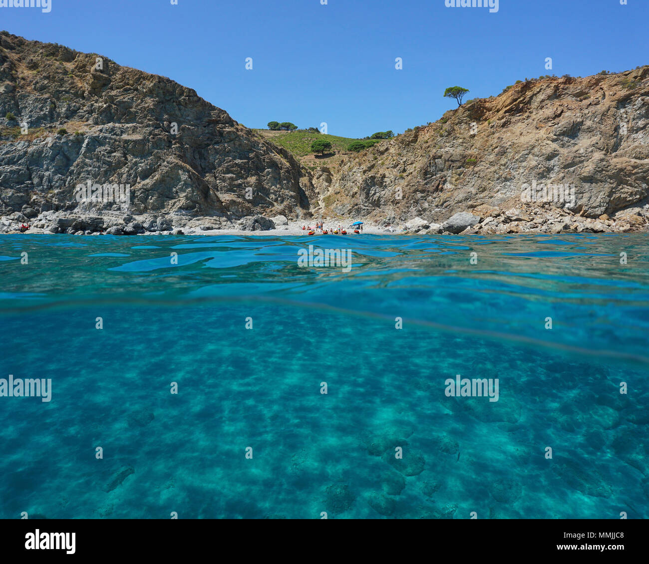 Felsige Küste mit einem einsamen Strand und einem sandigen Meeresboden Unterwasser, geteilte Ansicht oberhalb und unterhalb der Wasseroberfläche, Mittelmeer, Frankreich Stockfoto