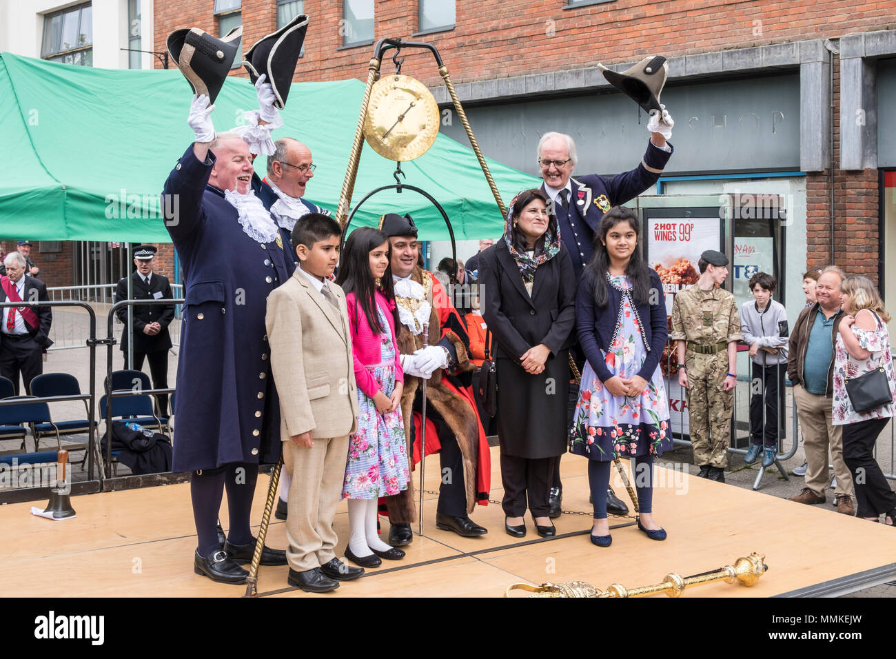 Samstag, 12. Mai 2018. High Wycombe, Buckinghamshire, England, GB, UK. Die urigen lokale Tradition von "Wiegen in der Bürgermeister' fand heute im Zentrum der Stadt. Traditionell werden die ausgehenden und eingehenden Bürgermeister und Bürgerliche Beamte sind zu Beginn der Amtszeit der Bürgermeister von Büro jedes Jahr gewogen, um festzustellen, ob Sie Gewicht auf Kosten der Steuerzahler gewonnen haben. Der neue Bürgermeister, Sarfaraz Khan Raja, die Frau Bürgermeisterin, Khola Kayani Raja und Ihre Kinder werden angezeigt. Credit: D. Callcut/Alamy leben Nachrichten Stockfoto