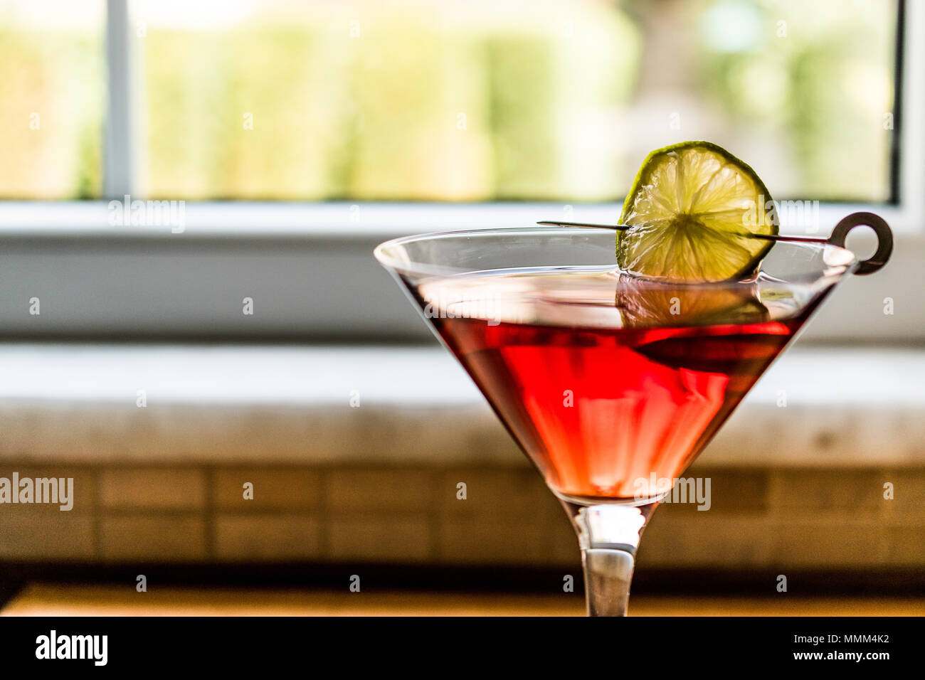 Cosmopolitan Cocktail mit Kalk auf Holz- Oberfläche. Beverage Konzept. Stockfoto