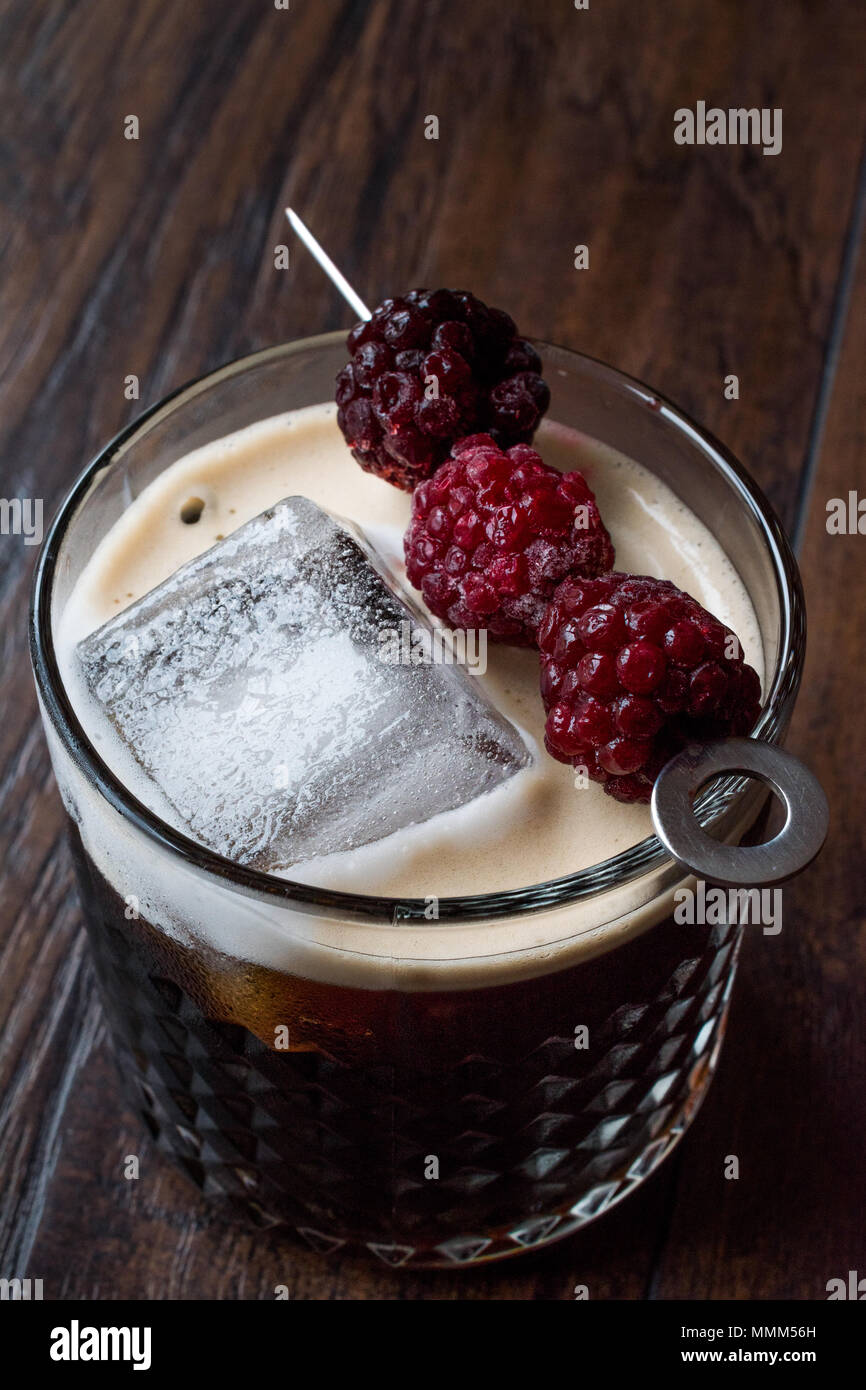 Schwarz/Dunkel Bier Cocktail mit Brombeeren und Eis auf Holz- Oberfläche. Beverage Konzept. Stockfoto