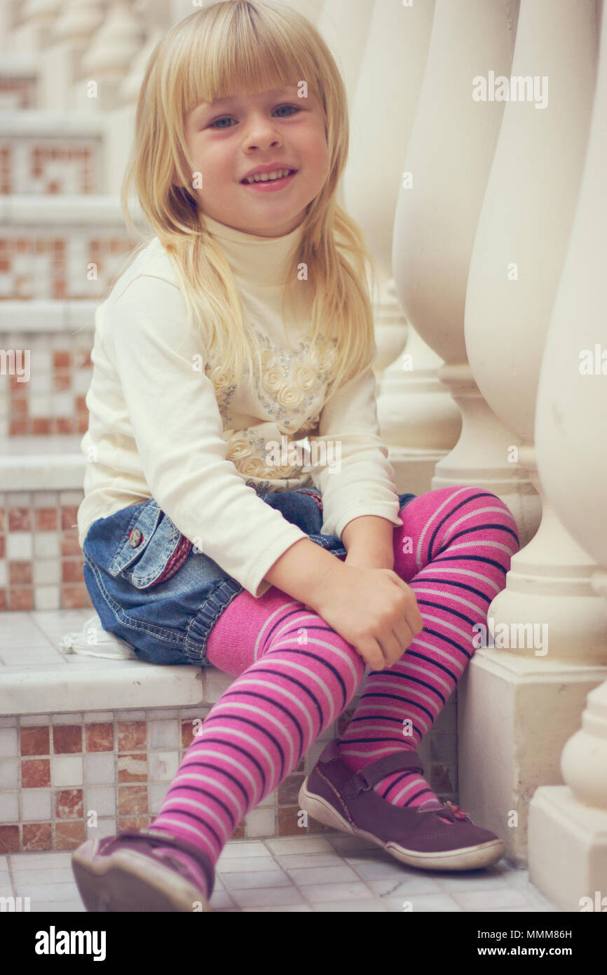 Mädchen 3 Jahre alt in einer Jeans Rock und rosa Strumpfhose sitzt auf  einem wunderschönen Treppe Stockfotografie - Alamy