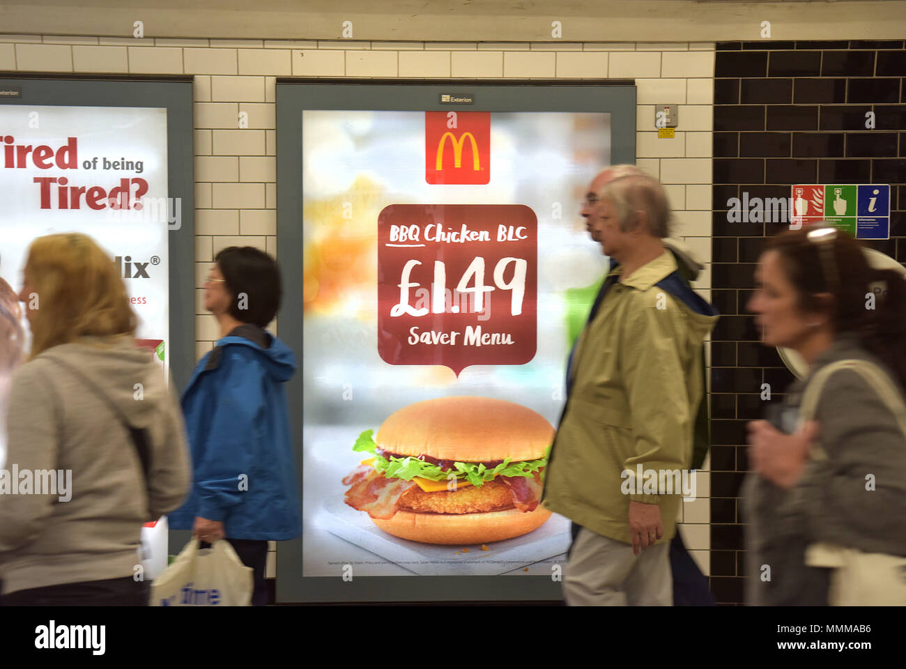 Menschen gehen vorbei Werbetafeln Förderung McDonalds BBQ Chicken Burger in der Notting Hill U-Bahn Station im Zentrum von London. Junk Food ad Stockfoto