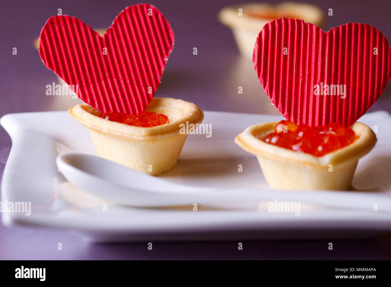 Törtchen mit rotem Kaviar und Papier Herzen zum Valentinstag Stockfoto