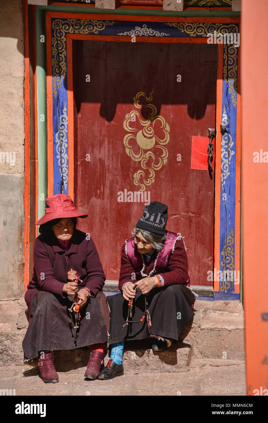 Tibetischen Pilger Spins ein Gebet Rad außerhalb des Heiligen Bakong Schrift Druckmaschine Kloster in Dege, Sichuan, China Stockfoto