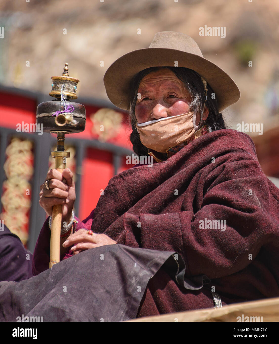 Tibetischen Pilger Spins ein Gebet Rad außerhalb des Heiligen Bakong Schrift Druckmaschine Kloster in Dege, Sichuan, China Stockfoto