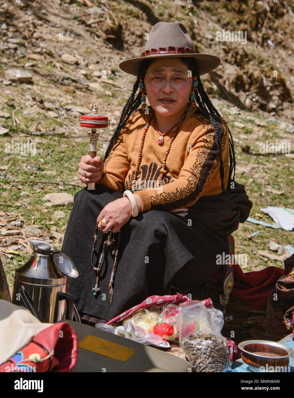 Tibetischen Pilger Spins ein Gebet Rad außerhalb des Heiligen Bakong Schrift Druckmaschine Kloster in Dege, Sichuan, China Stockfoto