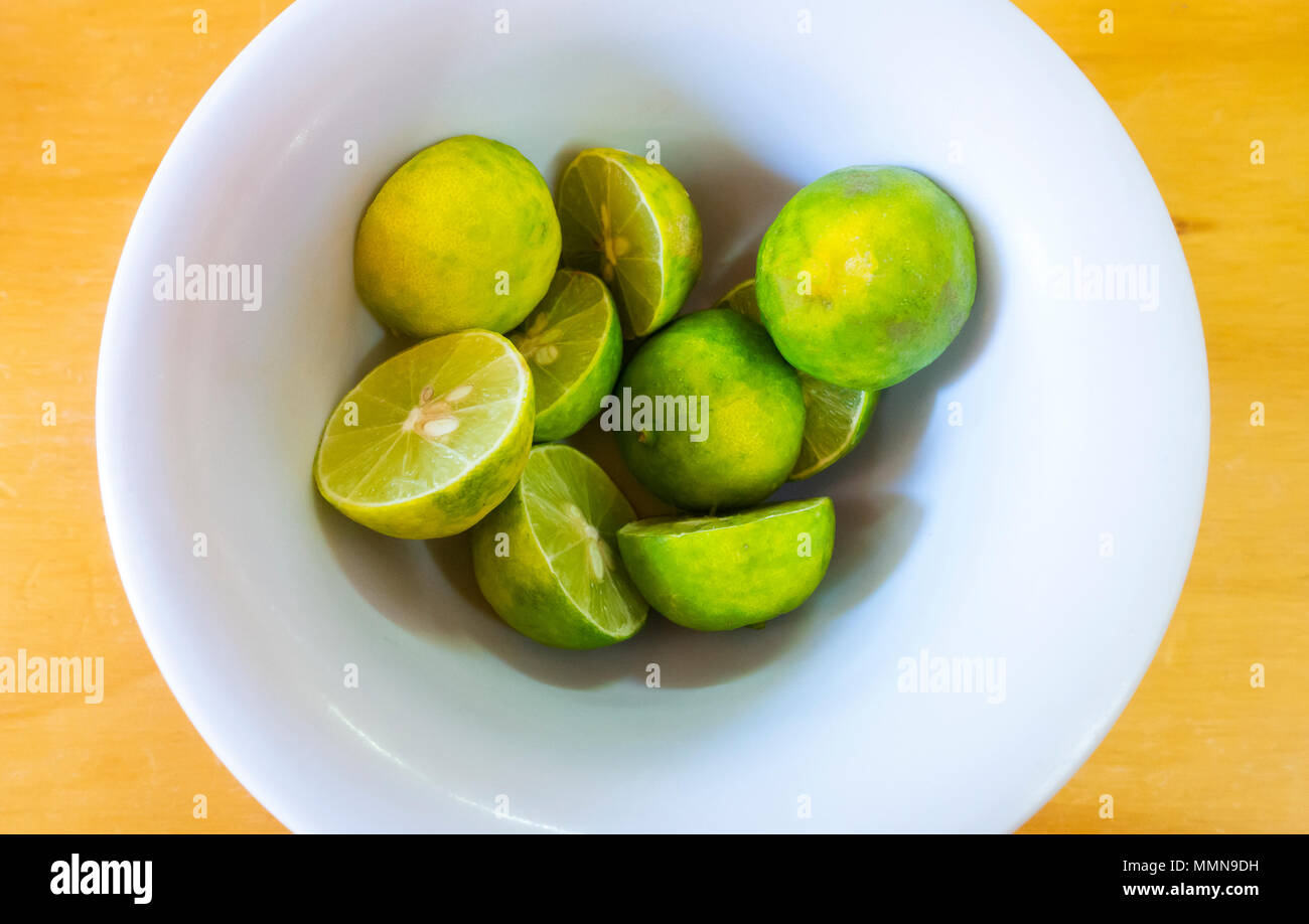 Eine Schüssel halbiert Frische grüne Zitronen Stockfoto