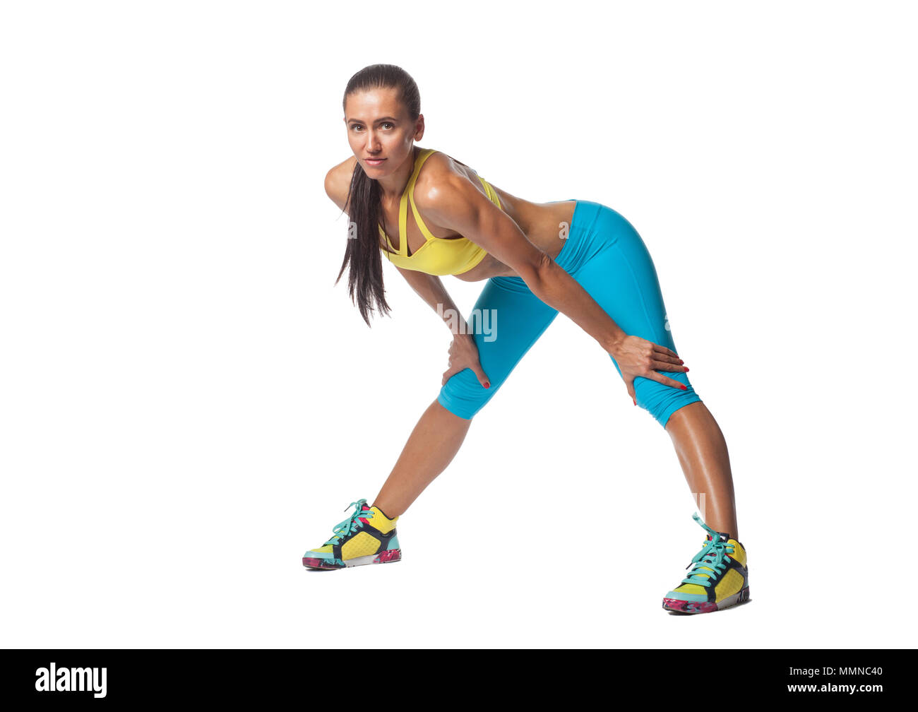 Attraktive Sportlerin in Sportkleidung bogen Blick auf Kamera auf weißem Hintergrund Stockfoto