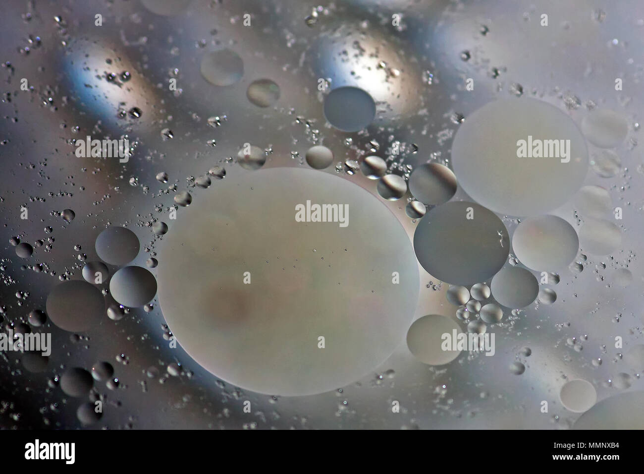 Abstrakte Muster als eine Myriade globuli von pflanzlichem Öl schwimmen auf Wasser. Stockfoto