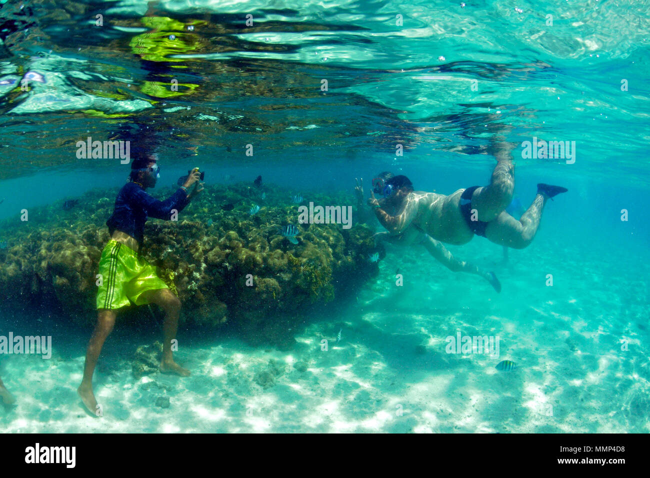 Ein schnorchler nimmt ein Bild von zwei Touristen um einen toten Korallenriff in den natürlichen Pools oder "gales", Maragogi, Alagoas, Brasilien Stockfoto