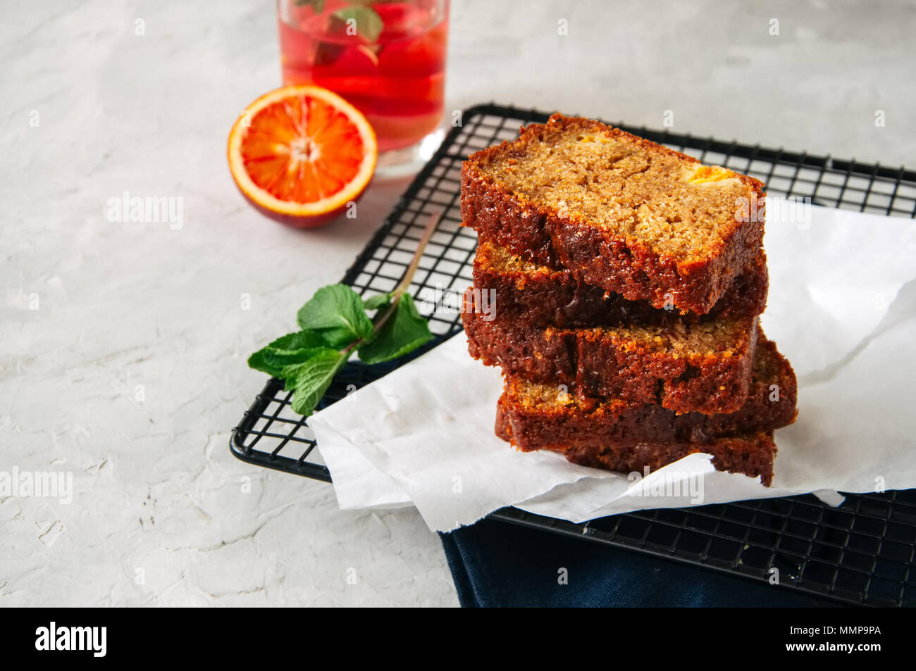 Scheiben von Blut orange vegetarische Pound Cake auf einem Rack. Weißer Stein Hintergrund. Stockfoto