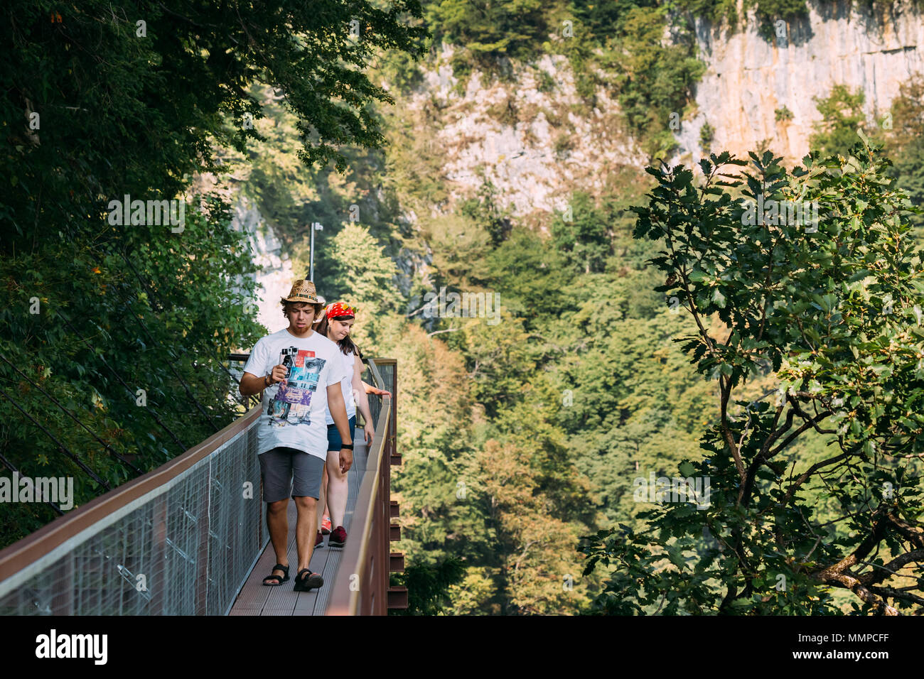 Zeda - gordi, Georgien - 13. September 2017: Menschen zu Fuß auf einer schmalen Hängebrücke oder Anhänger Straße bis zu 140 Meter über dem Abgrund auf dem Gebiet Okat Stockfoto