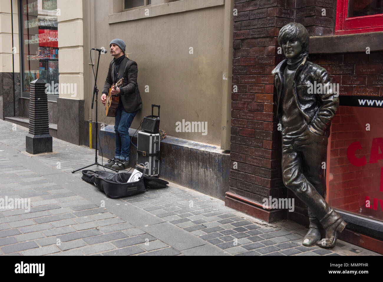 Busker neben der Statue von John Lennon in Matthew Street, Liverpool Stockfoto