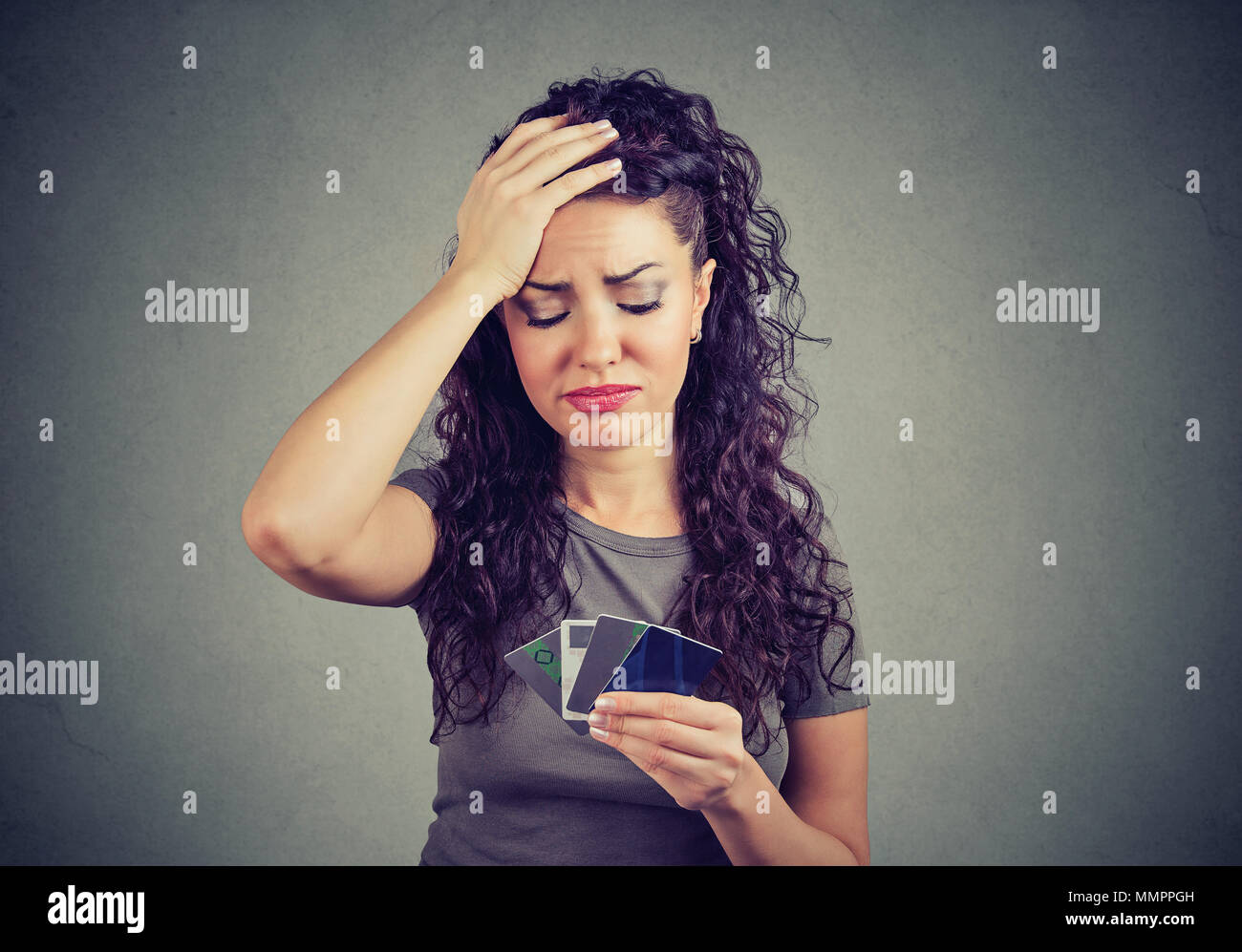 Verwirrt hob Frau an zu viele Kreditkarten suchen Stockfoto