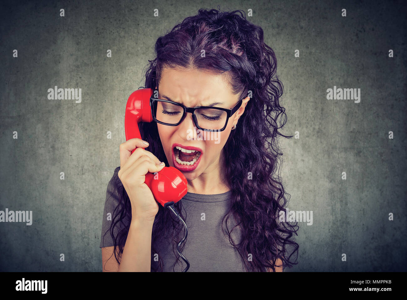 Junge wütende Frau schreiend auf dem Telefon Stockfoto
