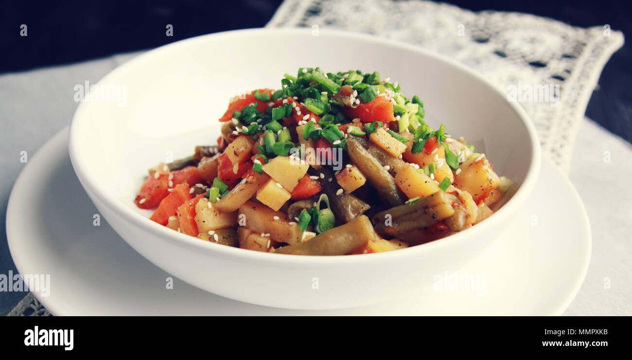 Gemüseeintopf mit Kartoffel, Karotte und grüne Bohnen mit Sesam. Europäische Küche. Gesund vegan Mittagessen auf der Runde weiße Platte. Europäische Stockfoto