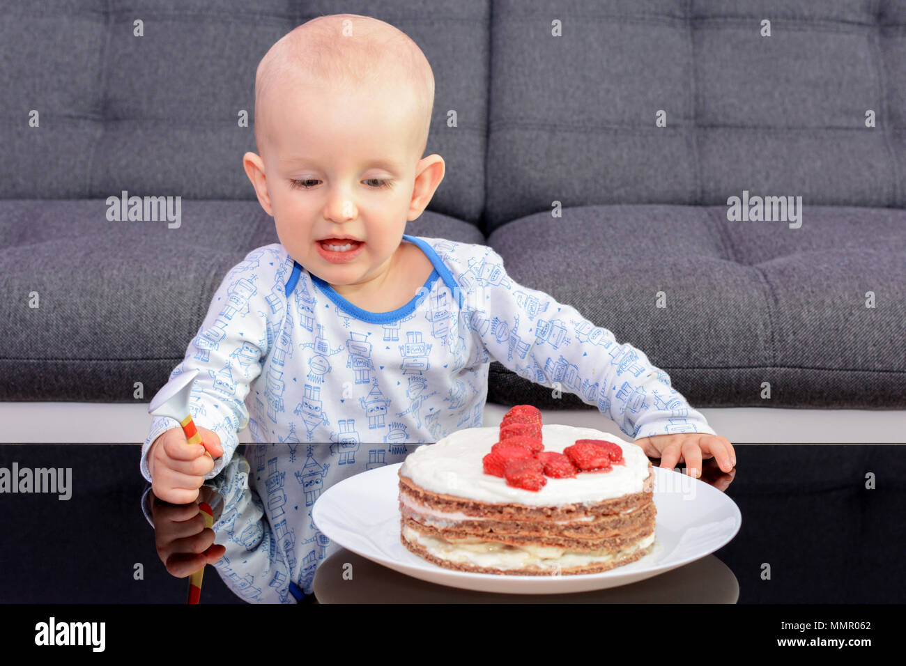 Der erste Geburtstag Feier eines kleinen Jungen. Little Boy essen Geburtstag  Kuchen mit einem Löffel, alles Gute zum Geburtstag. Kleinkind am Tisch mit  Kuchen Stockfotografie - Alamy