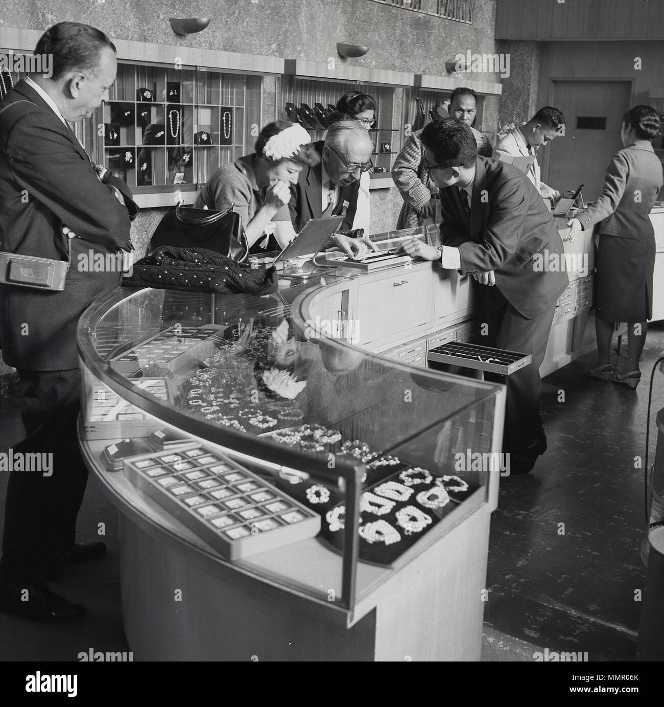 1950, historische, japanische Dame an einem Zähler anzeigen in einem Juweliergeschäft einige Perlen Schmuck von den männlichen Sales Assistant, Tokio, Japan gezeigt wird. Stockfoto