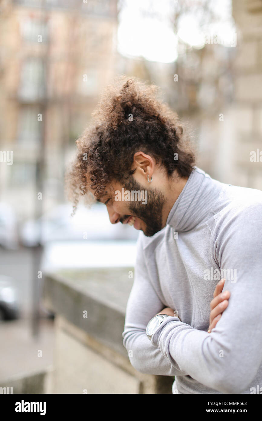 Die Hälfte der afrikanischen Mann mit grauen rollkragen pullover und Lockige braune Haare. Stockfoto