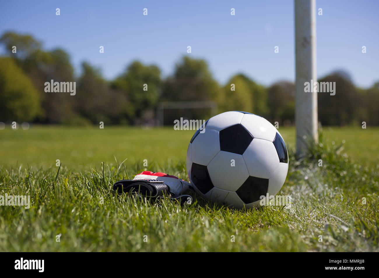 Ein Fußball aus Leder und Torwart Handschuhe in der Nähe von Post und Leitung Stockfoto