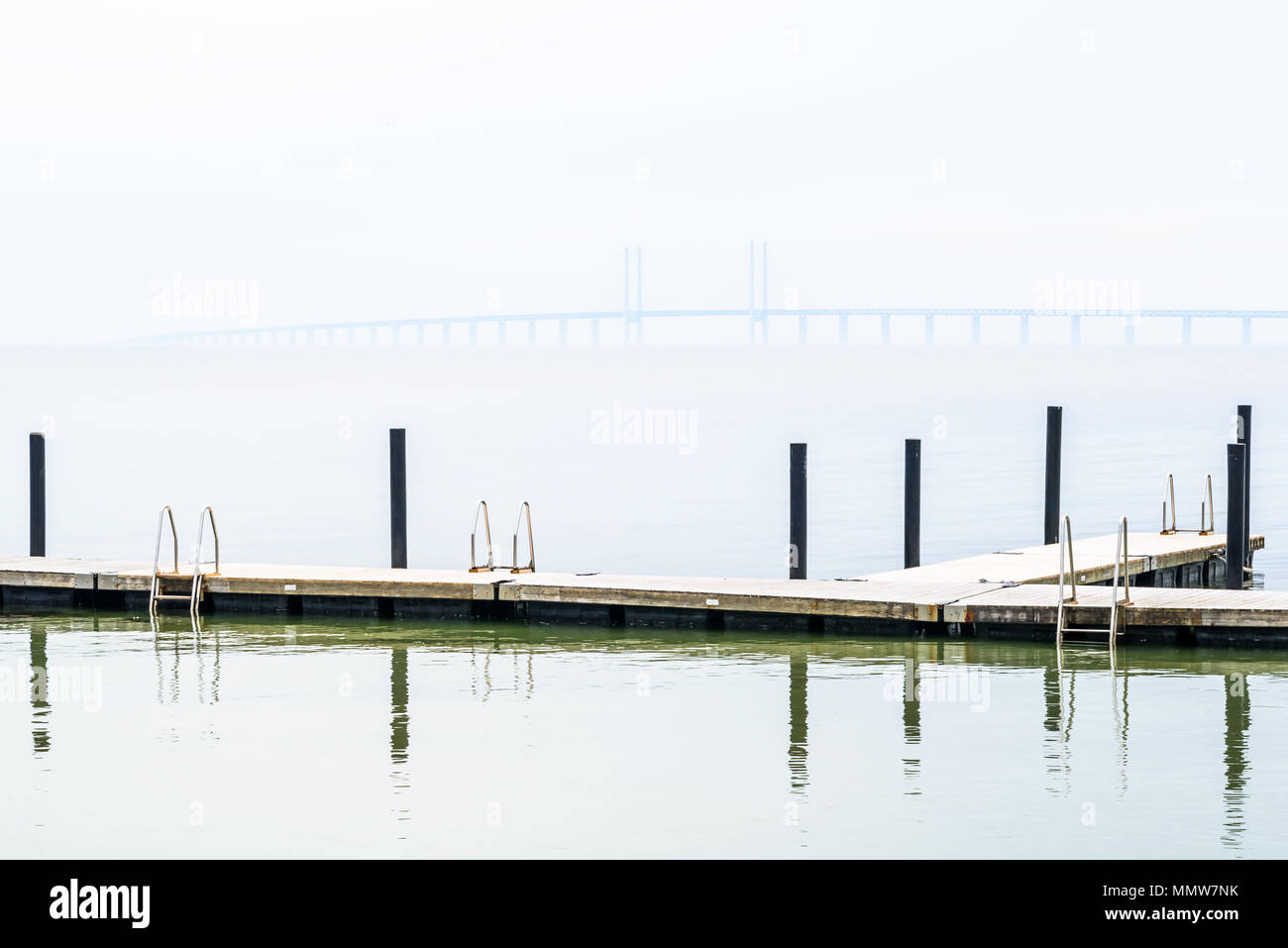 Kalgshamn, Schweden - ein Badesteg auf eine ruhige und nebliger Tag. Die Øresund-Brücke ist in der fernen Nebel sichtbar. Stockfoto
