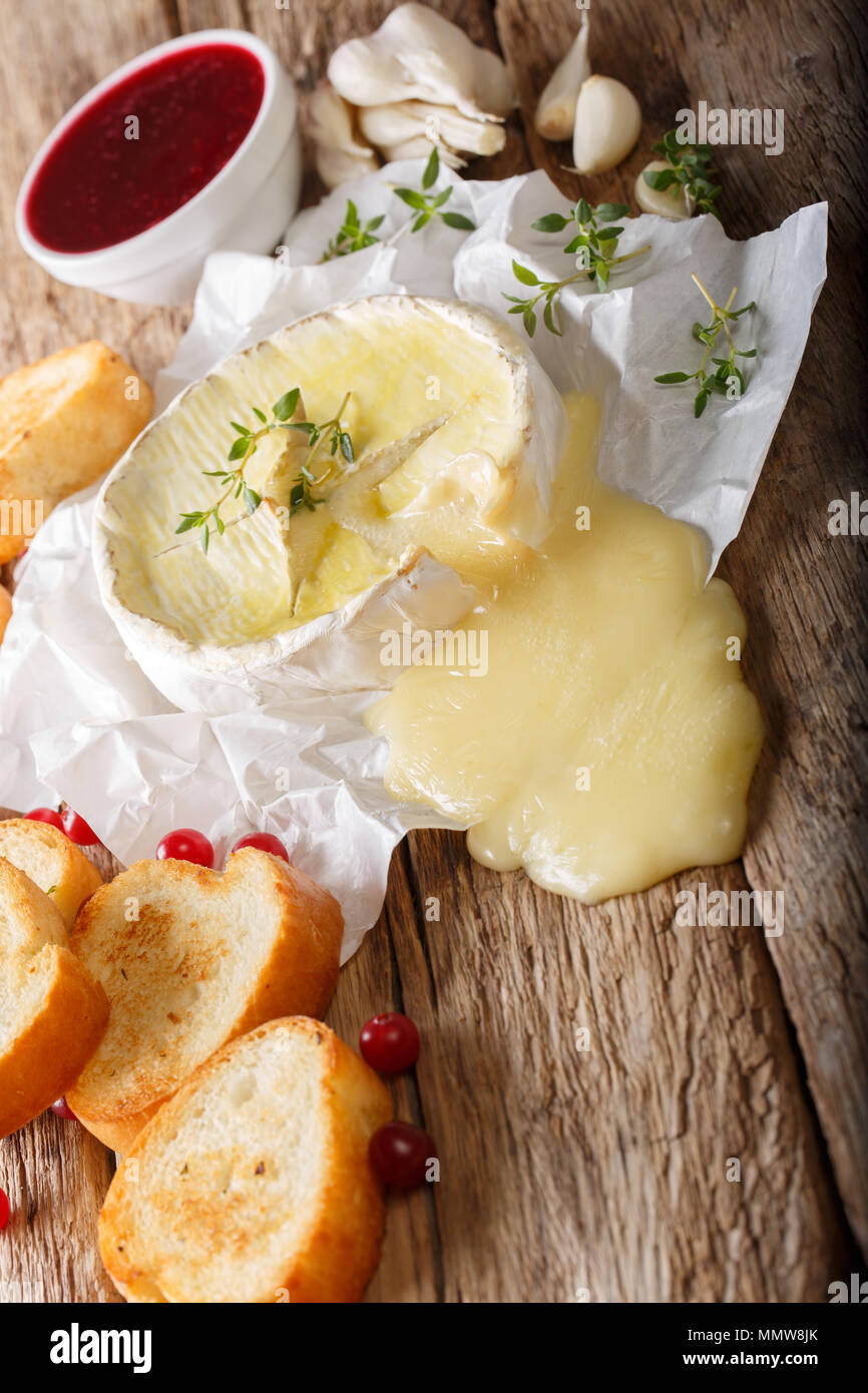 Französische Küche: Gebackener Camembert mit Toast und Preiselbeersoße close-up auf dem Tisch. Vertikale Stockfoto