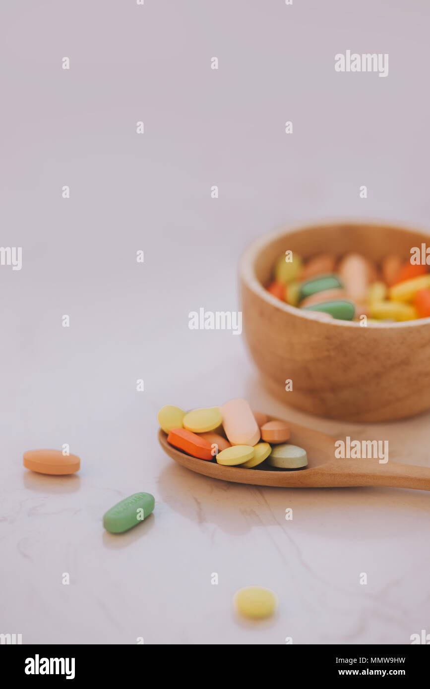 Verschiedene pharmazeutische Medizin Pillen, Tabletten und Kapseln auf hölzerne Schüssel Stockfoto