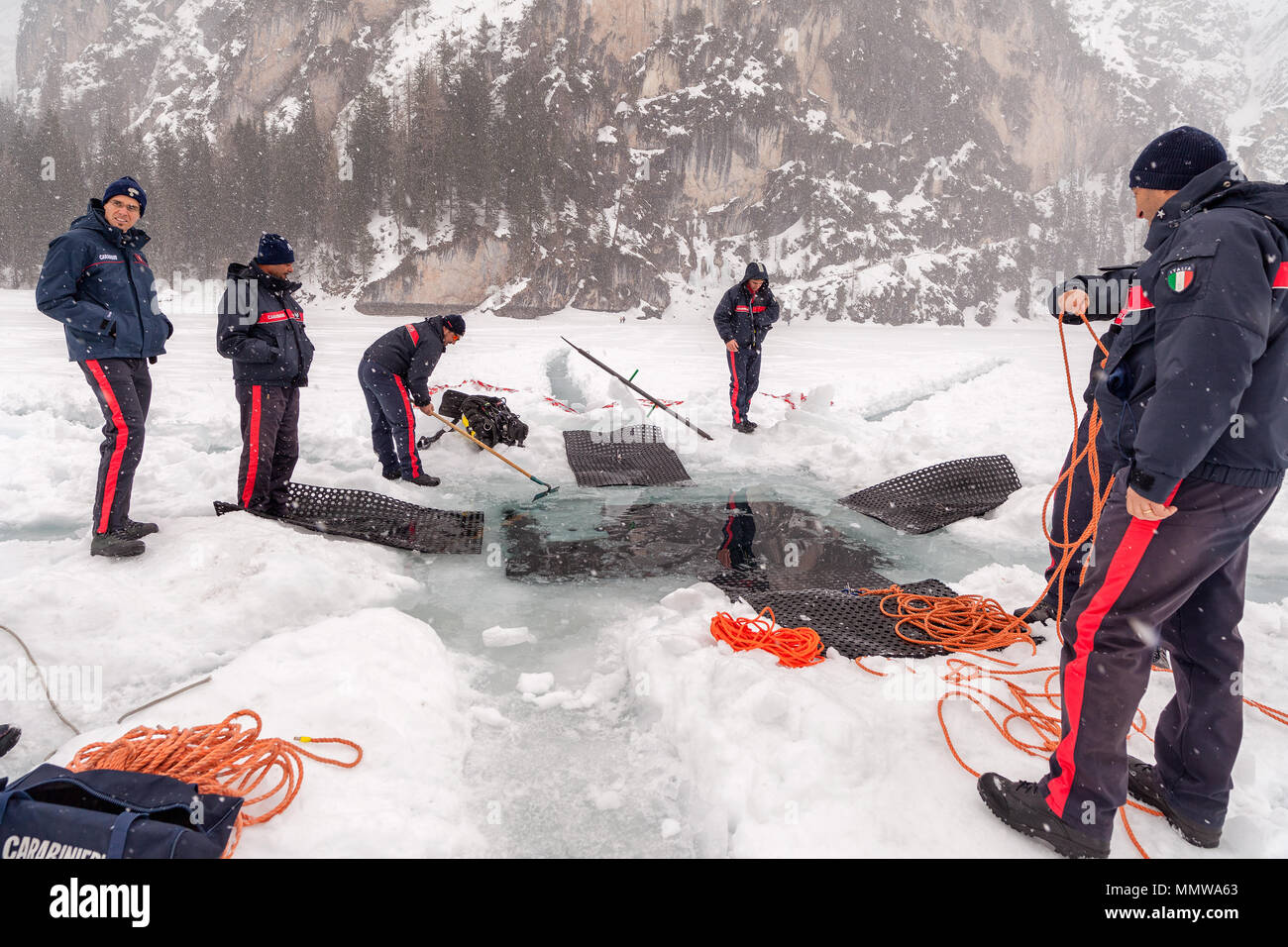 Pragser See, Italien, 10. März 2018: Italiener Carabinieri ein großes Loch graben tief in das Eis zu lassen Rescue Diver Einstieg in den See, Prags, Ita Stockfoto