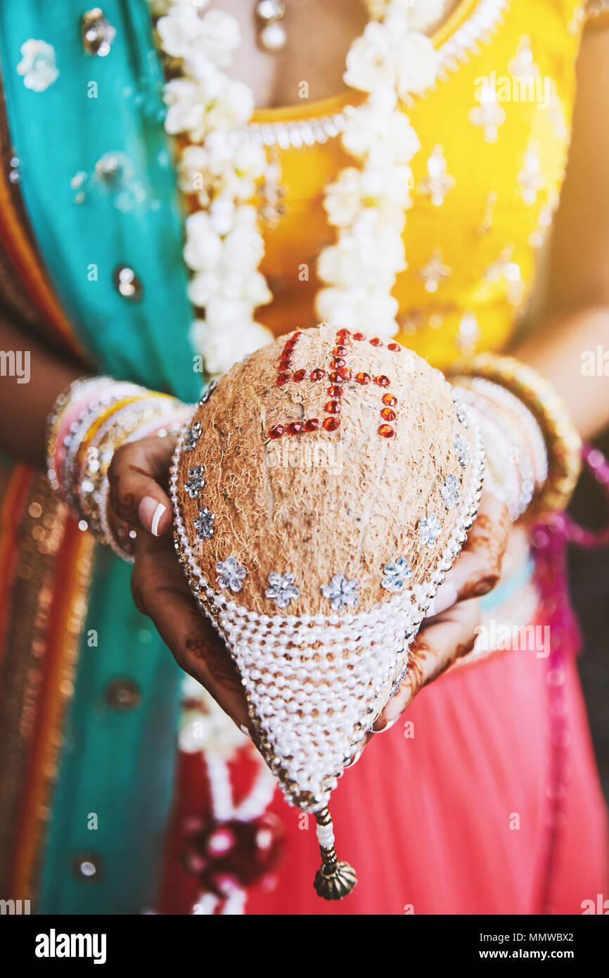Indiwn Braut hand mit mehndi (Henna) mit Bündel von Armbändern oder Armreifen auf ihr Handgelenk und nariyal der Holding die Kokosnuss shagun Los für das Gebet cerem Stockfoto