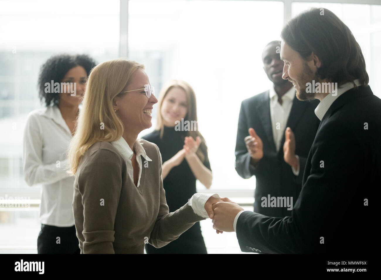 Boss handshaking lohnende weibliche Mitarbeiter gratulieren mit p Stockfoto