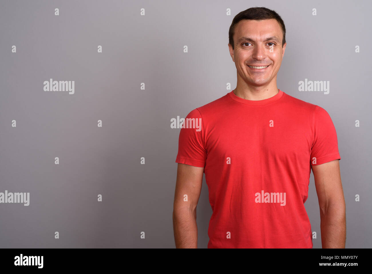 Mann mit roten Hemd gegen grauer Hintergrund Stockfoto