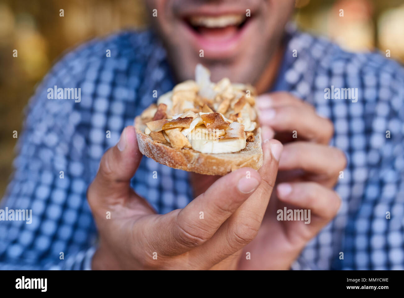 Lächelnd Mann über zu essen ein leckeres Sandwich konfrontiert Stockfoto