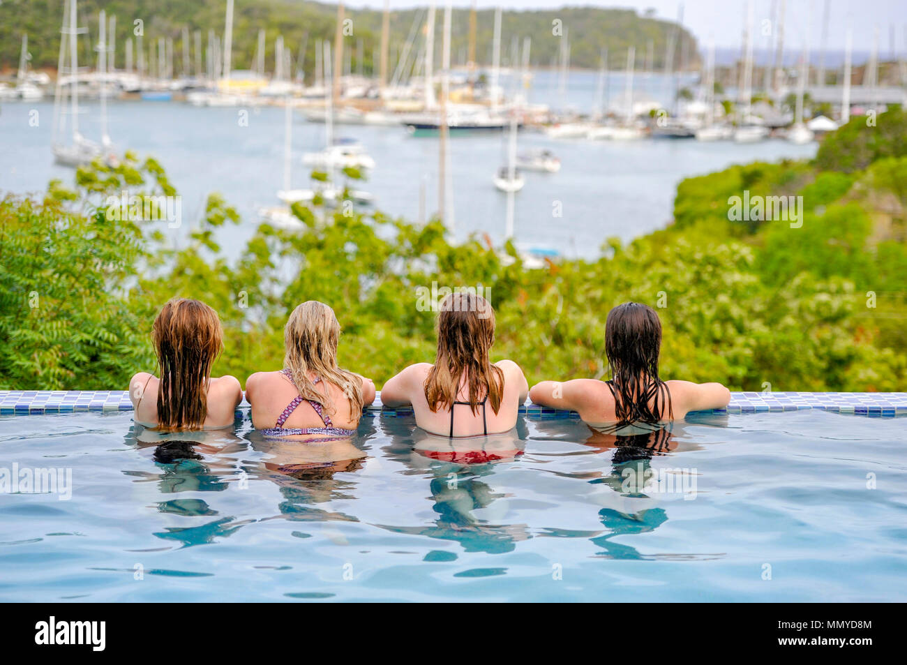 Antigua Inseln der Kleinen Antillen in der Karibik West Indies - vier junge Frauen genießen einen Infinity-Pool mit Blick auf English Harbour Stockfoto