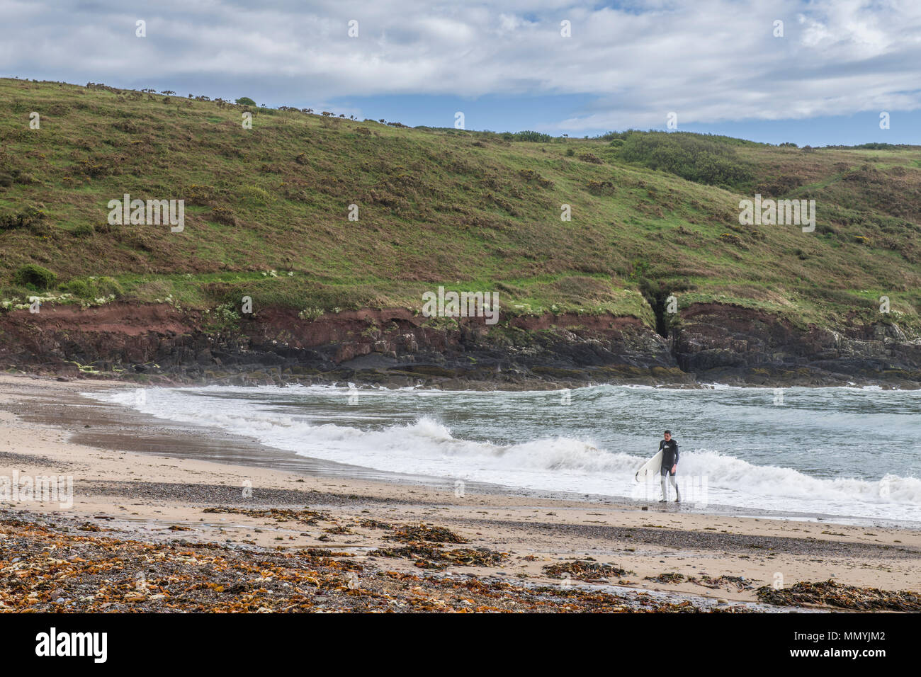 Surfer, die sich aus dem Meer in Manorbier Beach, South Pembrokeshire Wales Stockfoto