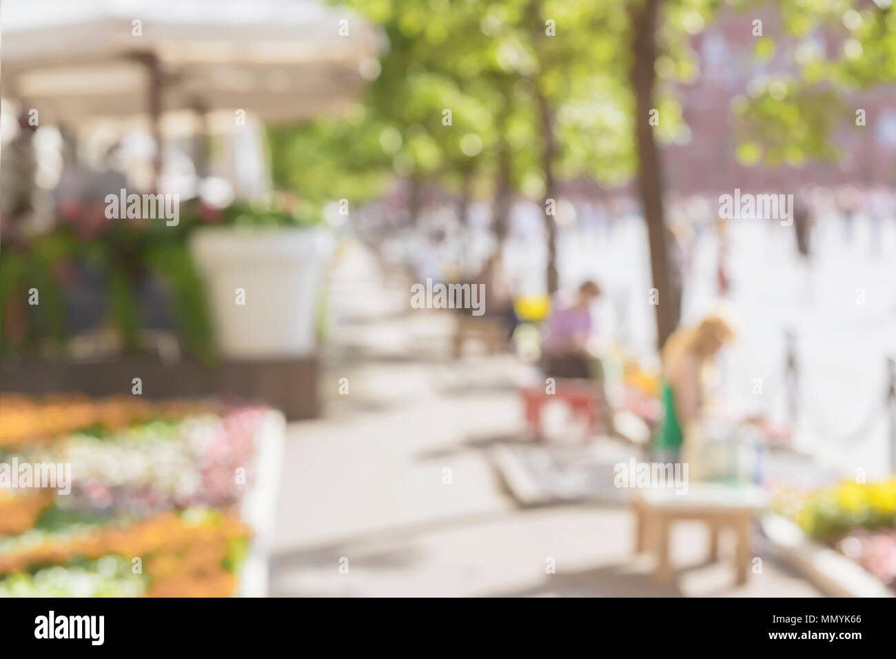 Nicht erkennbare Silhouetten von Menschen zu Fuß in der Stadt und auf den Bänken in der sonnigen Tag. Urban modernen abstrakten Hintergrund. Verschwommen Effekt Stockfoto