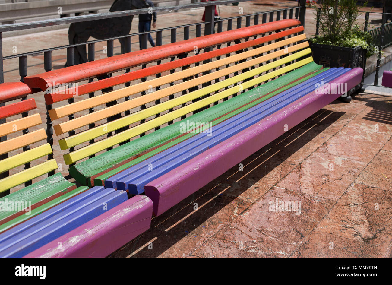 Ein Regenbogen gemalt Sitzbank in Oviedo. Stockfoto